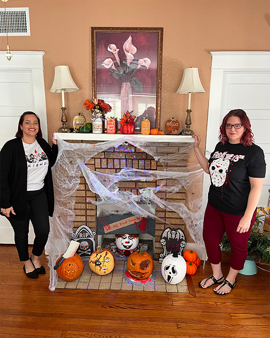 Two women smiling on Halloween decors