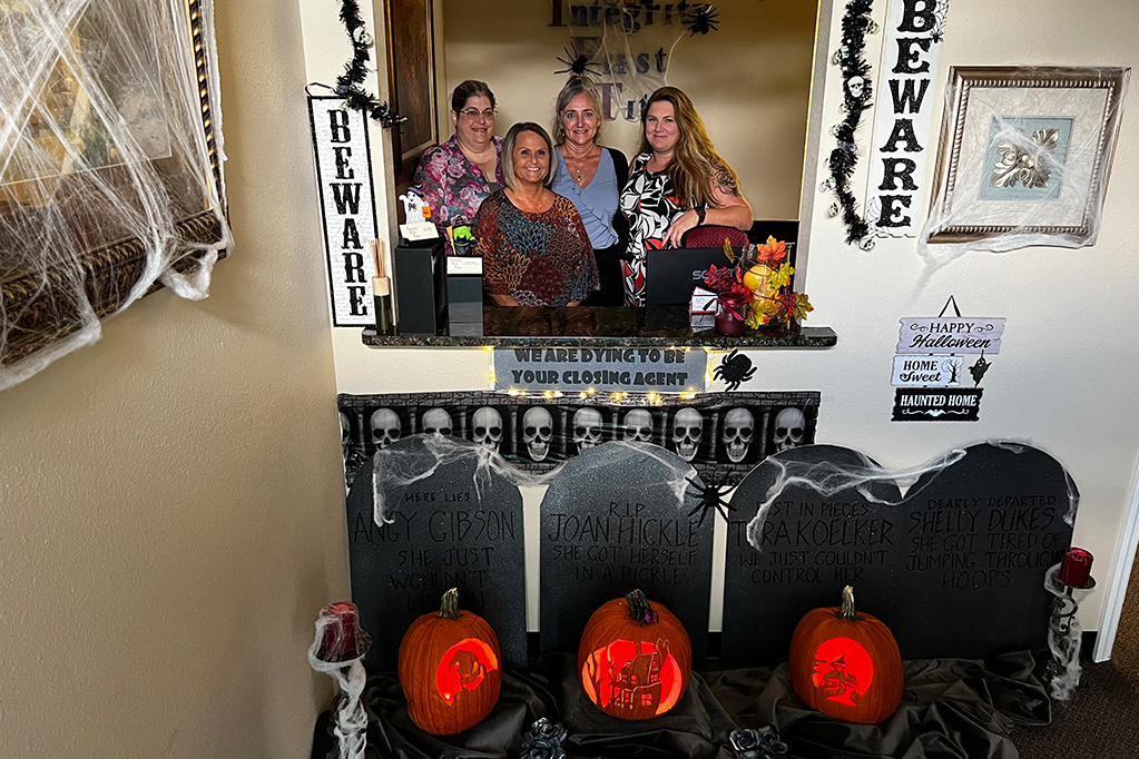 Four Women smiling in front of the mirror with Halloween decoration
