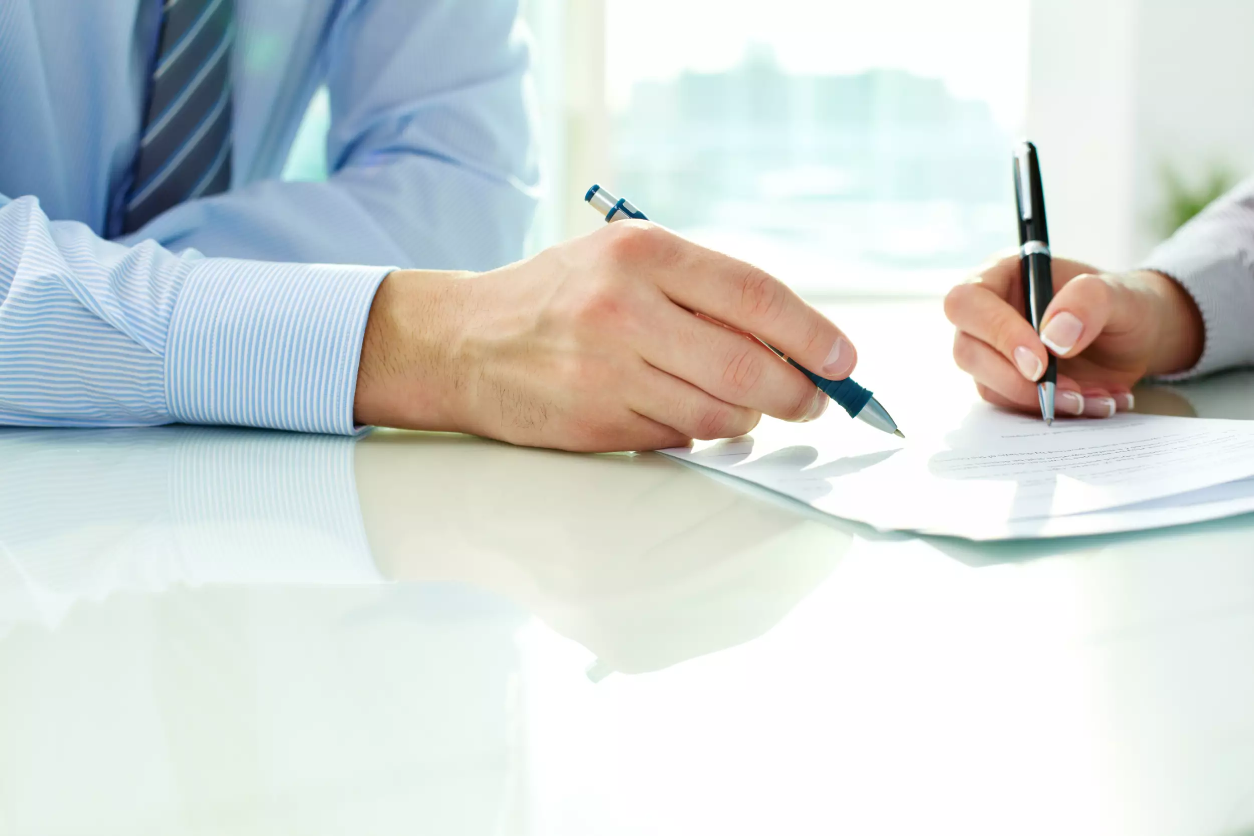 A man and woman signing mortgage documents